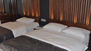 A hotel room with two beds, wooden headboards, and vertical wooden slats on the walls. - Admiral Hotel (Kocasinan)