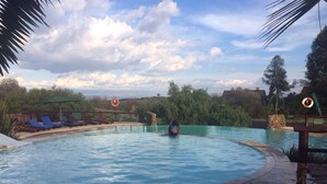 A swimming pool with lounge chairs and a lifeguard stand. - Marula House (Naivasha)