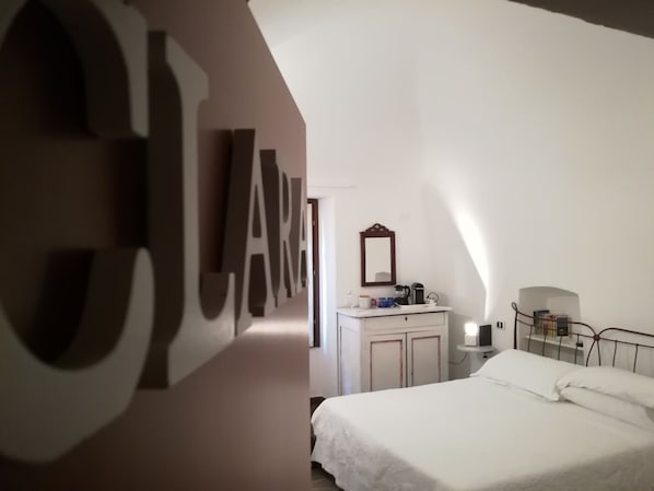 A bedroom with a large bed, a dresser, a mirror, and a wall-mounted light fixture. - B&B La Terrazza (Bordighera)