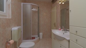A bathroom with a toilet, shower, sink, and mirror. - Rooms Center of Trogir (Trogir)