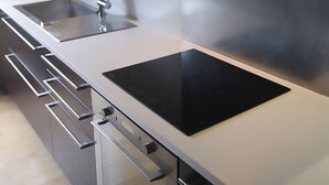 A modern kitchen with stainless steel appliances, a double sink, and a built-in oven. - Vintage houseboat rider ... (Saint-Rémy-de-Provence)