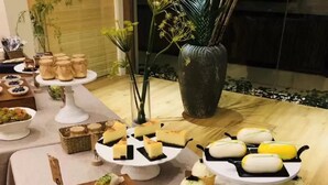 Une table de buffet proposant divers plats, notamment des pâtisseries, des gâteaux et un pot de confiture.