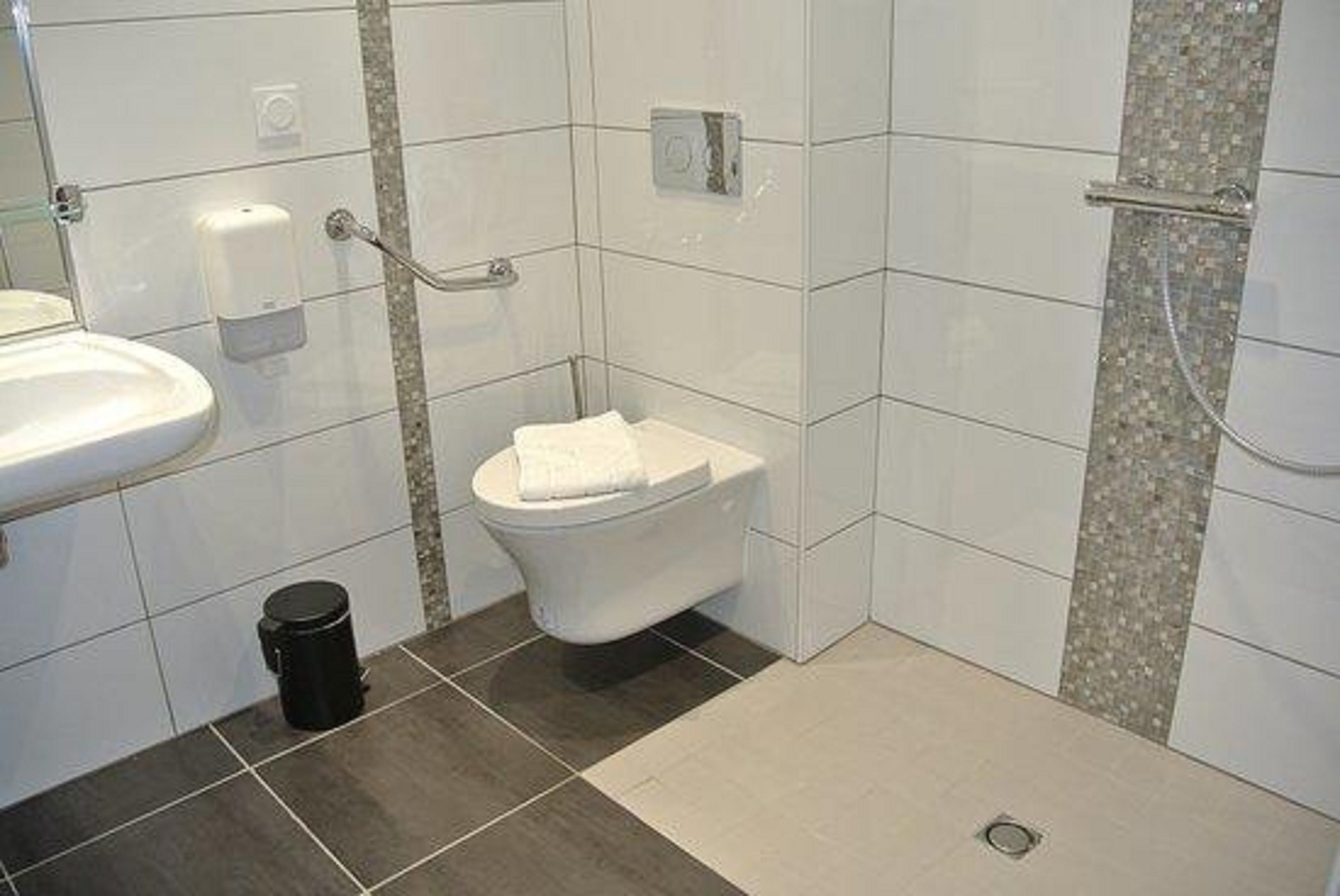 A bathroom with a toilet, sink, and shower.