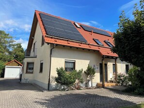 A two-story house with a red-tiled roof, solar panels, and a small balcony. - Disabled apartment (ground floor apartment) near Erfurt (Herbsleben)