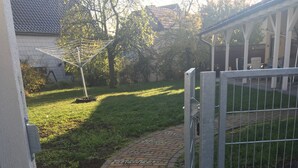 Un vialetto lastricato che conduce a un ingresso delimitato da un cancello in metallo.