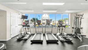 Une salle de sport équipée de tapis de course, d’un vélo d’appartement et d’appareils de musculation.