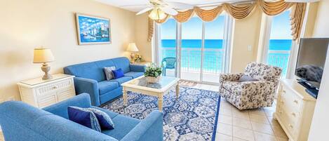 A living room with a blue sofa set, a coffee table, and a patterned rug.