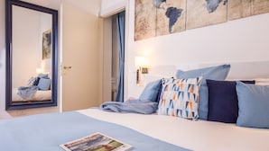 A hotel room with a bed, a nightstand, a lamp, and a map on the wall.