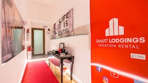 A modern hotel lobby with a red carpet, a glass display case, and a motivational quote on the wall.