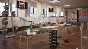 Ein Fitnessstudio mit verschiedenen Trainingsgeräten, darunter Laufbänder, Ergometer und Kraftgeräte.