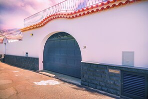 Stylish building with a curved entrance and red-tiled balconies.