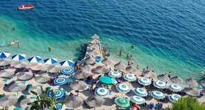 A beach with umbrellas and lounge chairs.