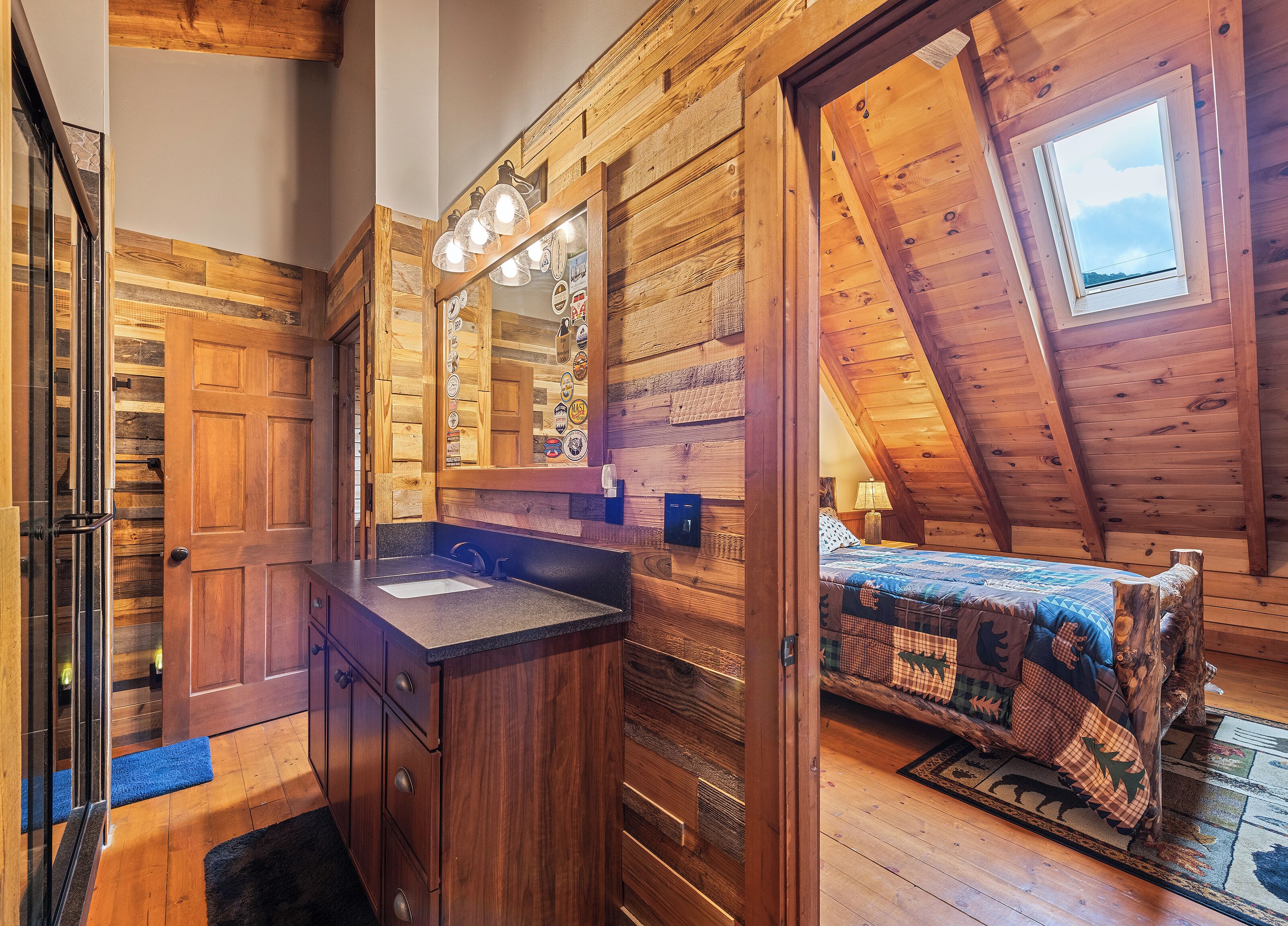 L’intérieur d’une cabane en bois, avec une salle de bain, un lit et une lucarne.