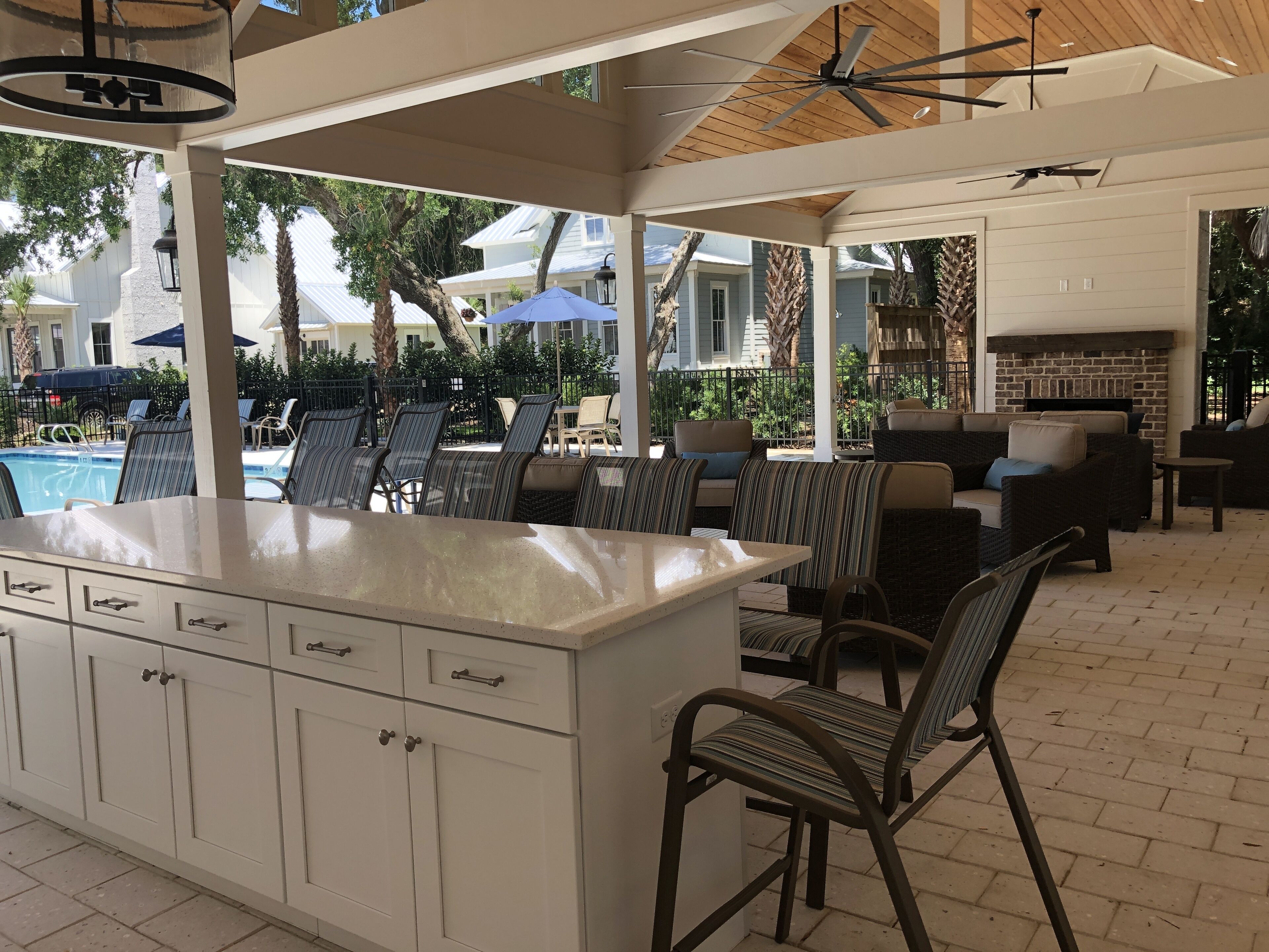 An outdoor patio area with a pool, lounge chairs, and a fireplace.