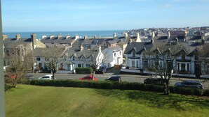 A coastal residential area with houses, a road, and a view of the sea. - Princetown Guesthouse (Bangor)
