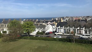A residential area with houses, a clear sky, and a view of the sea. - Princetown Guesthouse (Bangor)