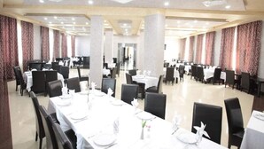 Un comedor amplio con varias mesas y sillas, dispuesto en una distribución simétrica.