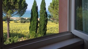 A window view of a coastal landscape with trees and a field of yellow flowers. - Charm and hospitality at 500 meters from the sea. Pool surrounded by greenery (Civitanova marche)