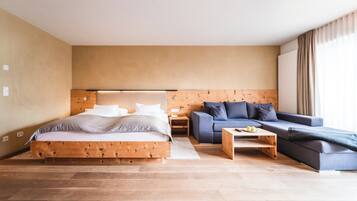 Un dormitorio moderno con una cama de madera, un sofá azul y una mesa de centro de madera.