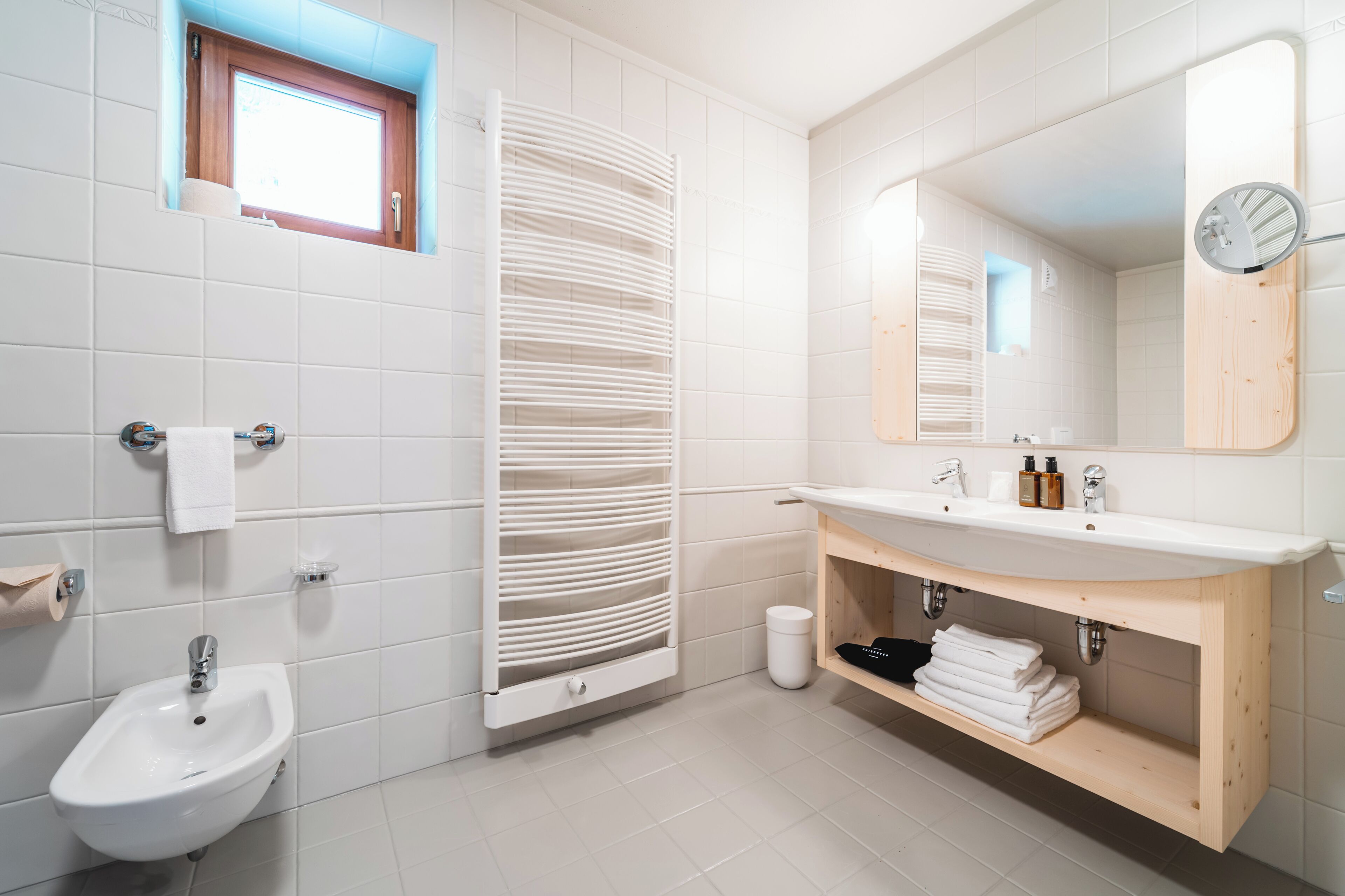 Une salle de bain moderne avec un lavabo blanc, un meuble-lavabo et un bidet.