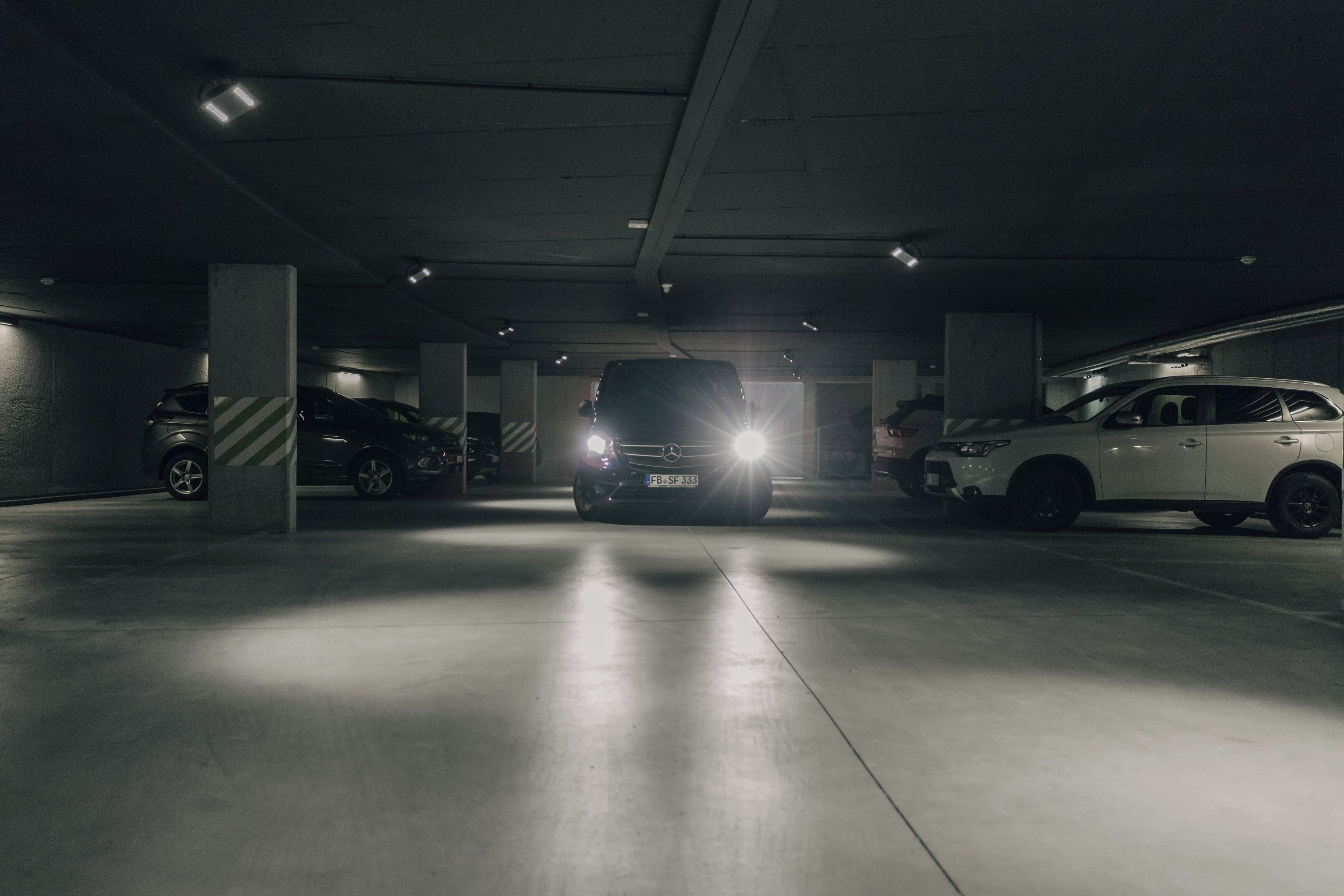 A parking garage with multiple cars parked.