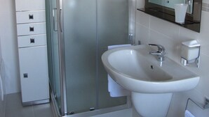 A modern bathroom with a glass-enclosed shower, a white sink, and a large mirror. - Bed & Breakfast Villa Filotea (Desenzano del Garda)
