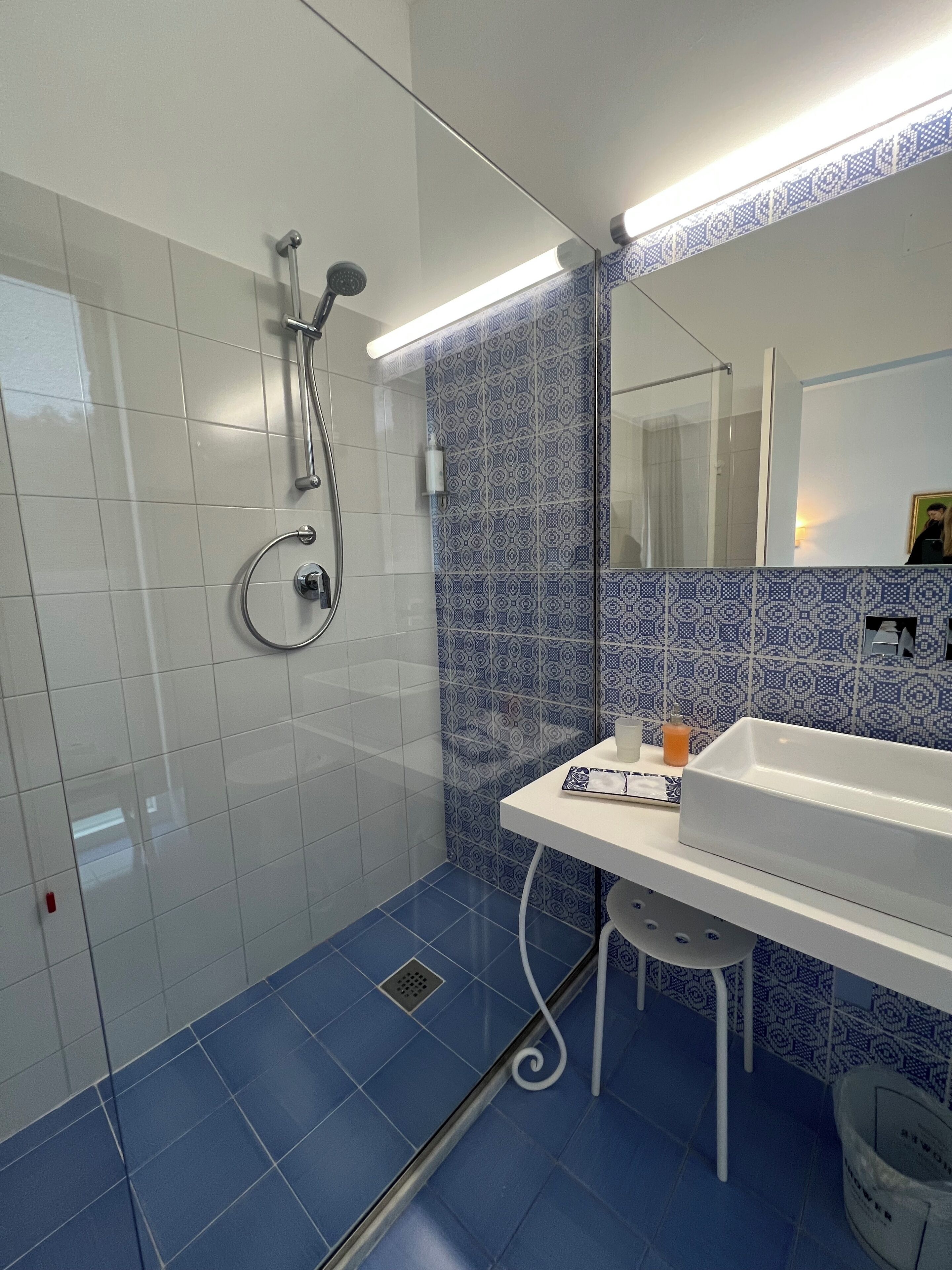 Un baño con ducha, lavabo y espejo.