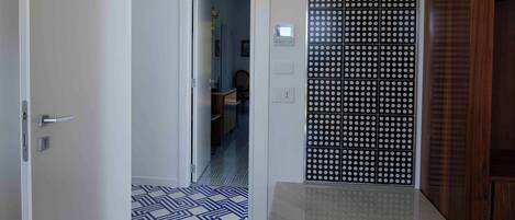 A room with a patterned floor, a wooden cabinet, and a white door.