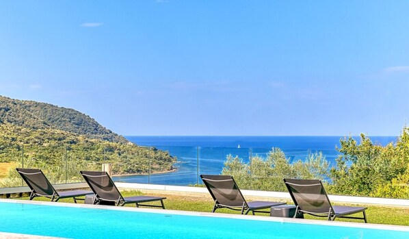 Piscine extérieure en saison, parasols, chaises longues
