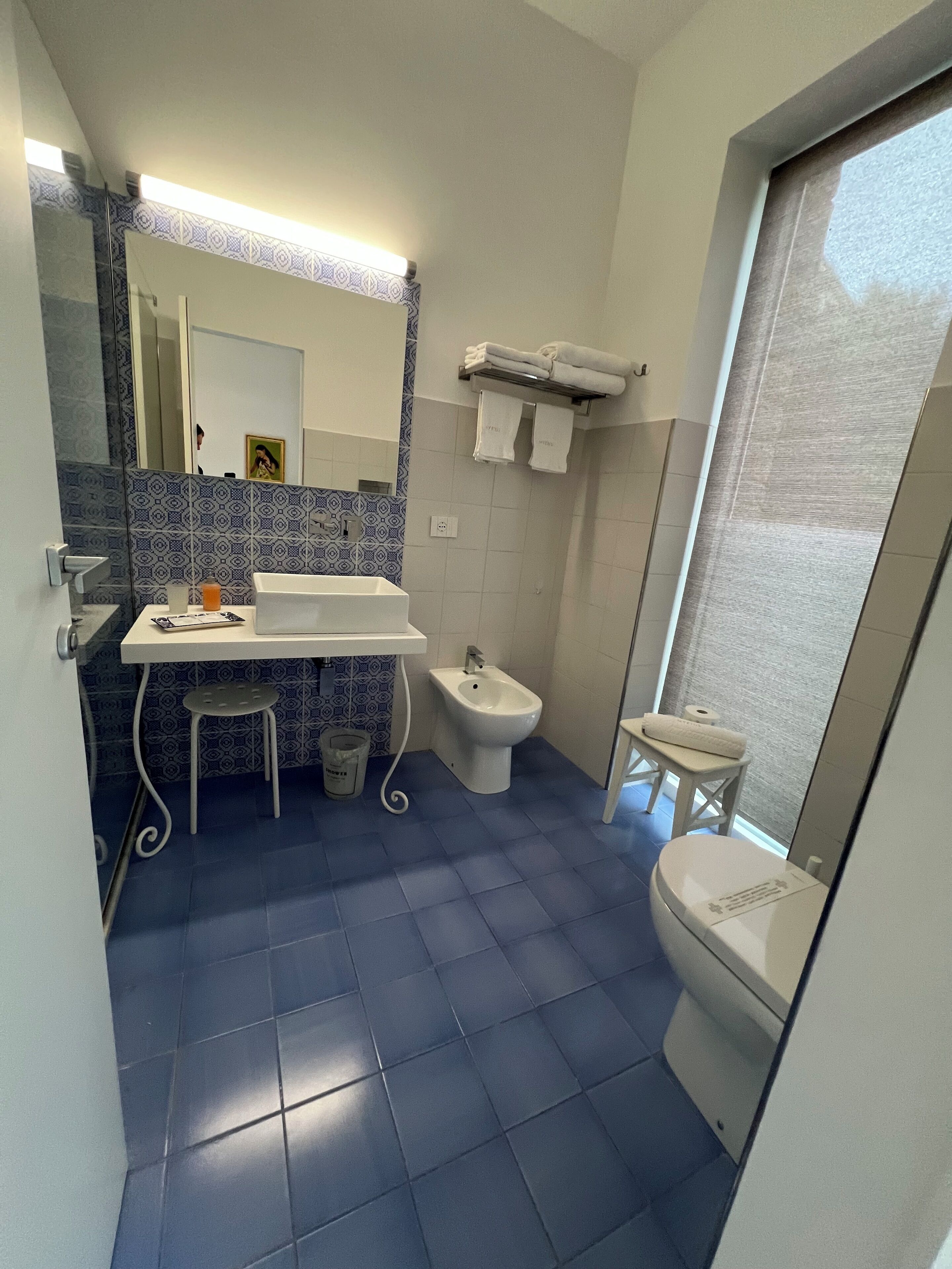 Un bany amb bidet, vàter, rentapel i un petit tamboret.