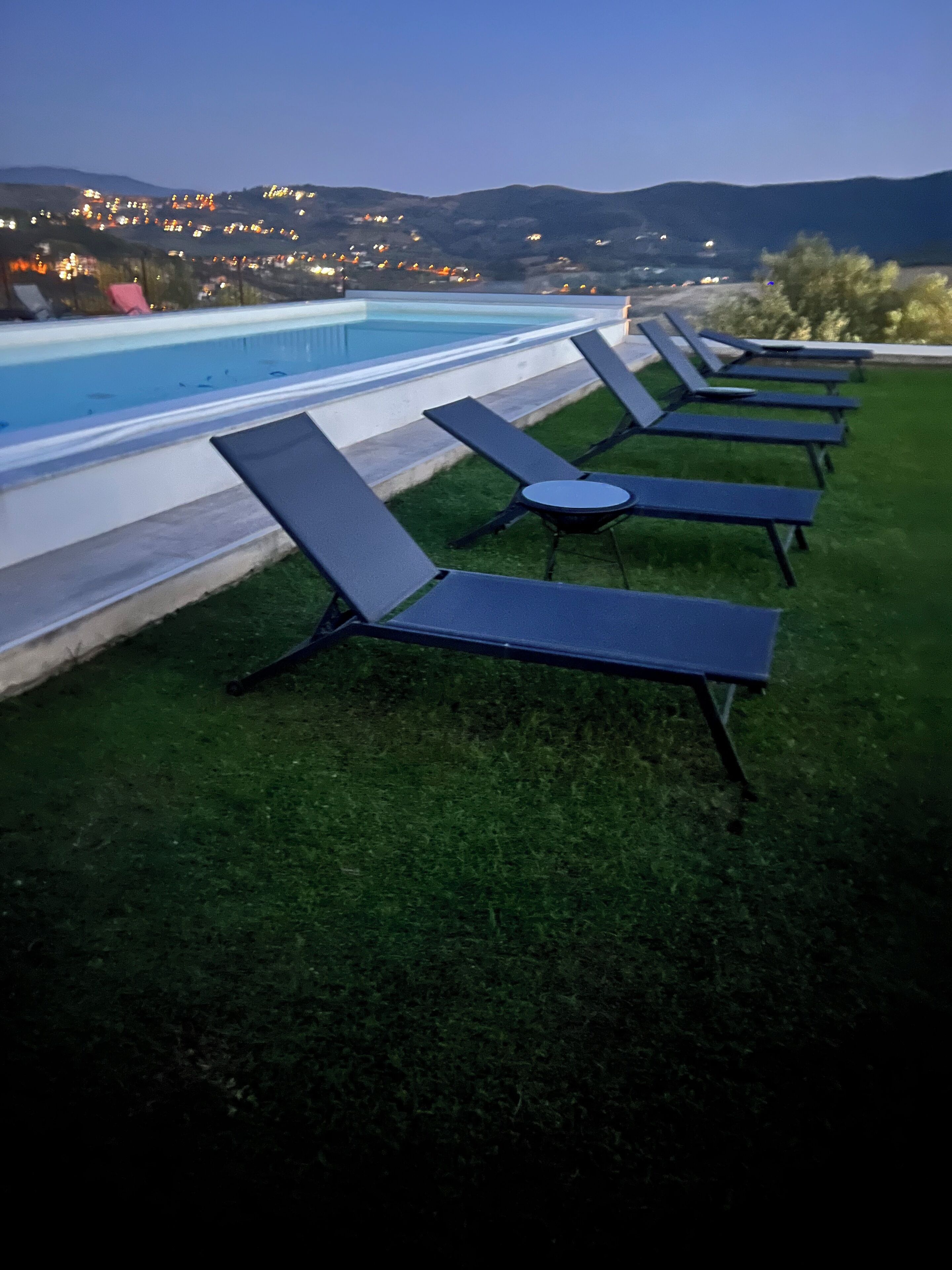 Un espace aménagé au bord de la piscine, avec des chaises longues et une piscine.