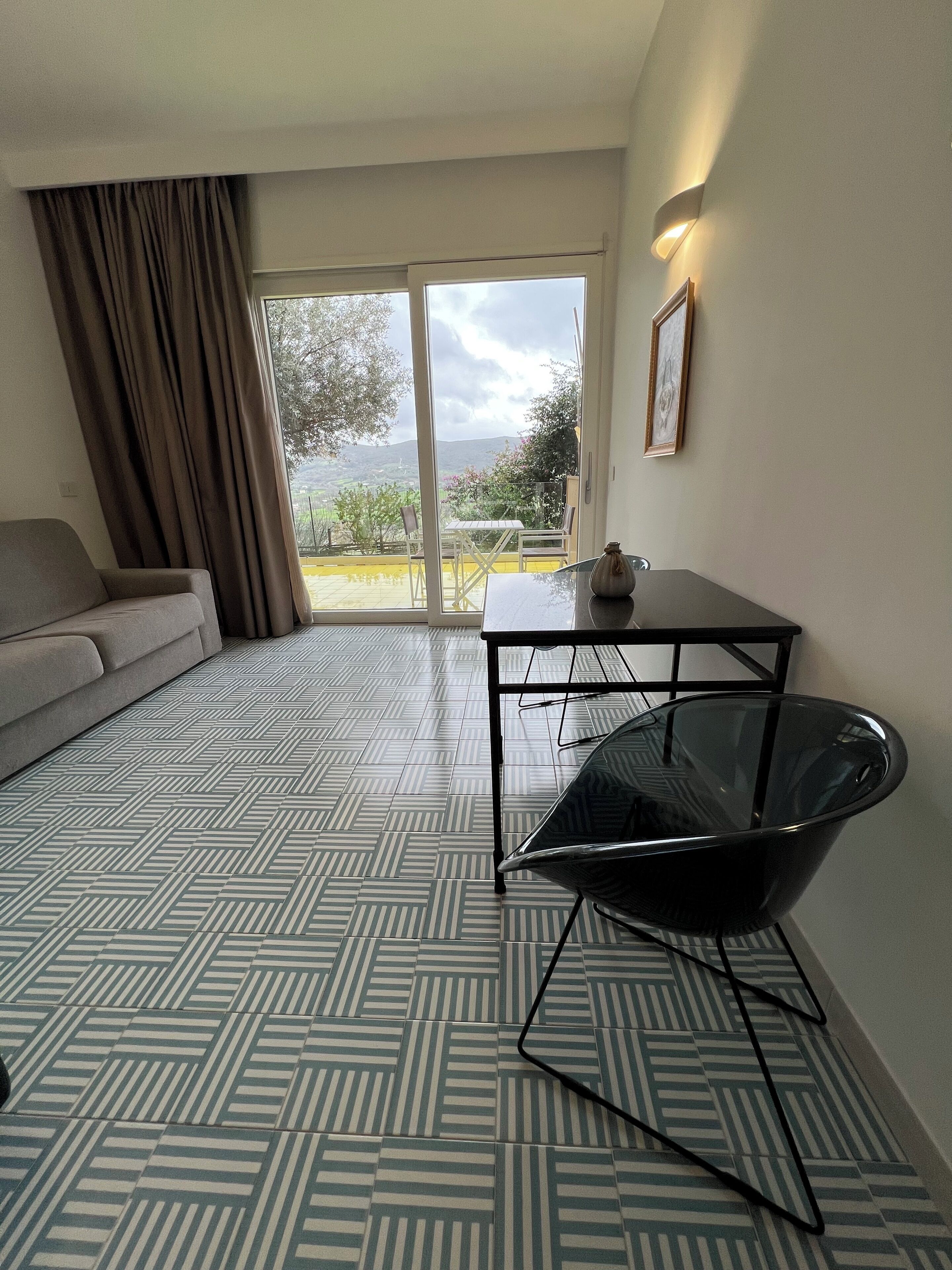 Una sala moderna con un sofá, una mesa de vidrio y una silla.