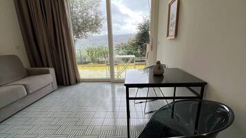 Una sala moderna con un sofá, una mesa de vidrio y una silla.