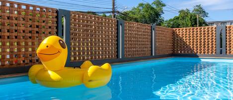 A swimming pool with a yellow inflatable duck float.