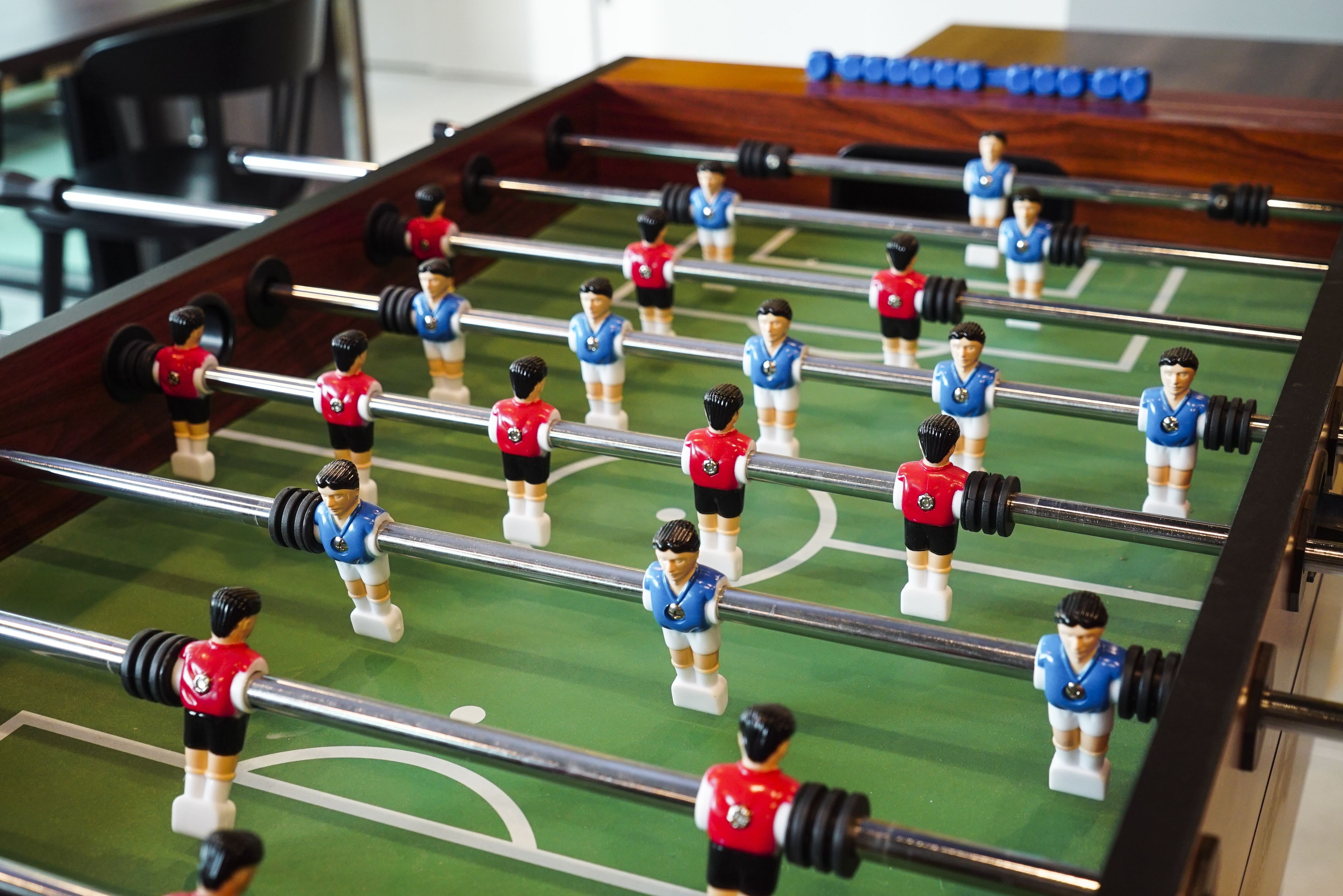 A foosball table with players in red and blue uniforms.