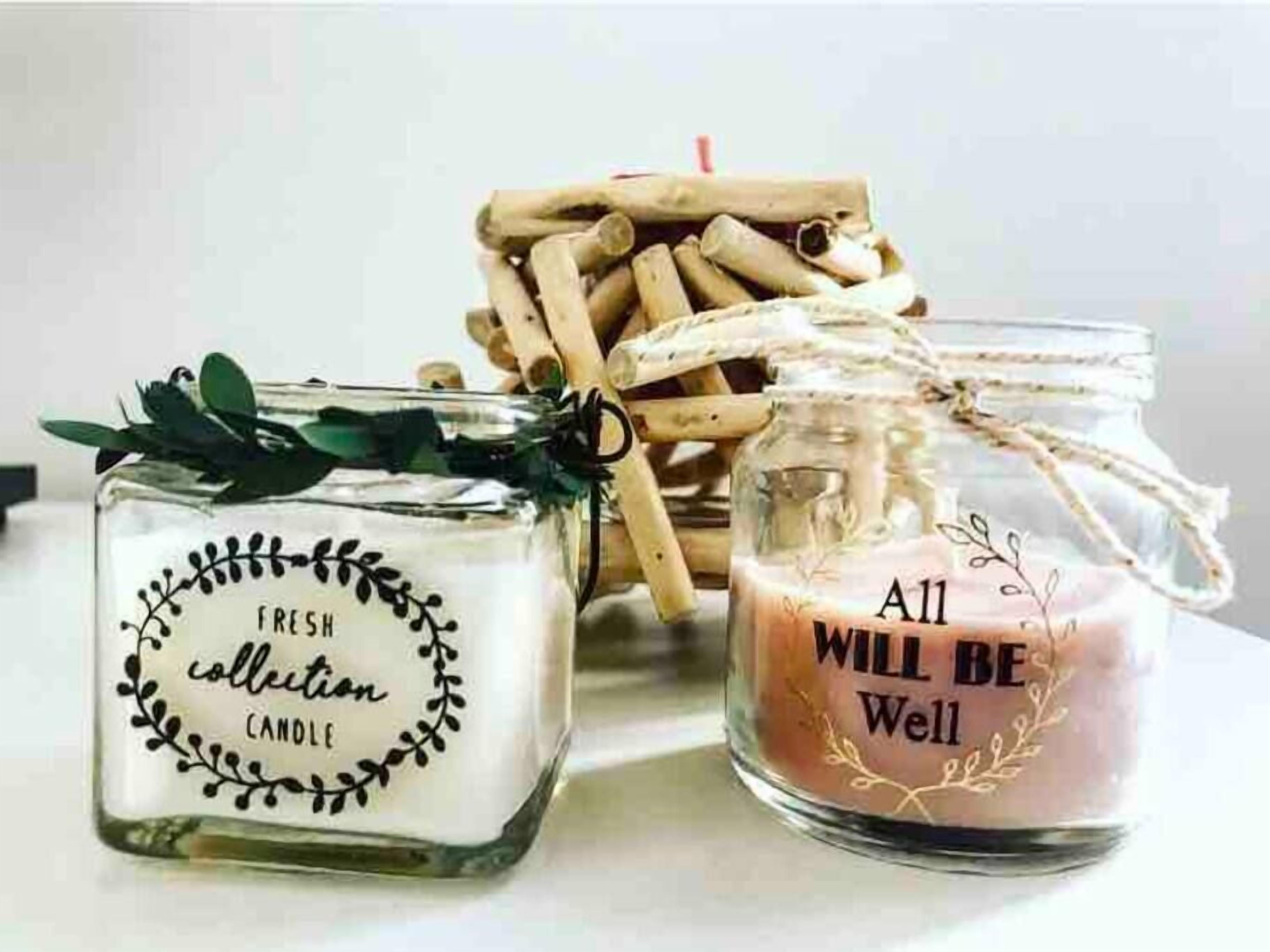 Two glass jars with candles, one labeled "Fresh Collection Candle" and the other "All Will Be Well."