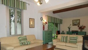 A living room with two beige sofas, a wooden coffee table, and a green cabinet. - Charming town on 400m² of fully enclosed land (Elne)