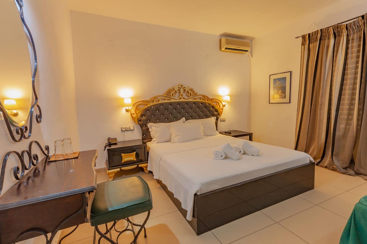 A hotel room with a large bed, bedside tables, a desk, and a chair.
