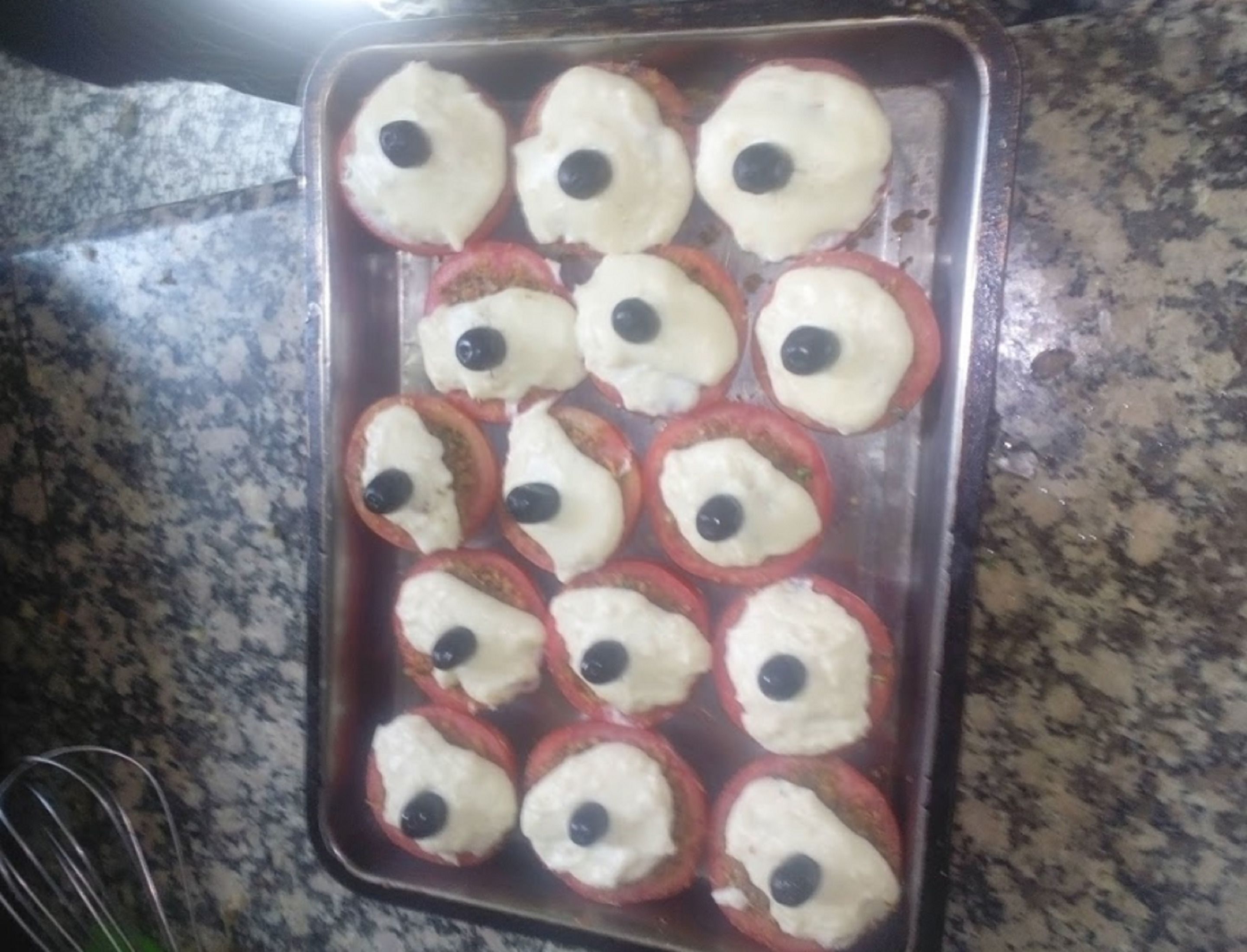 Una bandeja de productos horneados con glaseado blanco y cobertura negra.