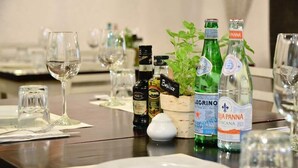 A dining table set with wine glasses, bottles of wine, and a small plant. - Unic Design Hotel (Playa del Carmen)