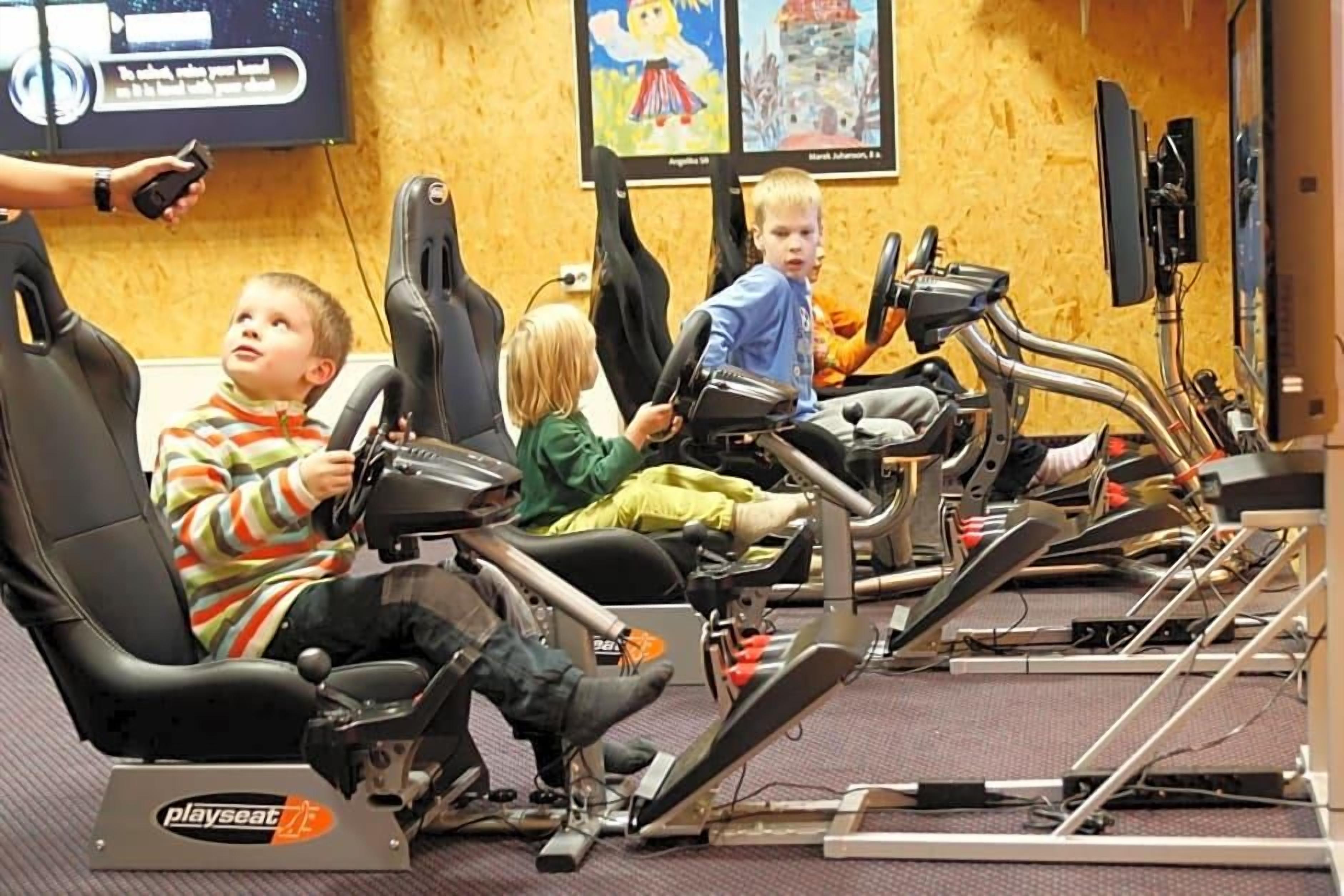 A play area with stationary bikes and a television screen in the background.