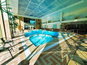 An indoor swimming pool with a tiled floor, lounge chairs, and a mural on the ceiling. - Sanatorium & Spa Toila (Toila)