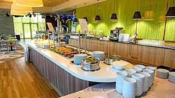 A buffet setup with various food items and serving utensils.
