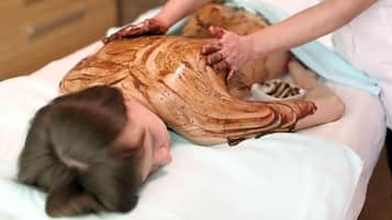 A person lying on a treatment table receiving a massage.