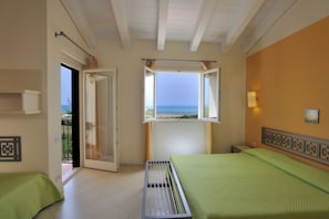 A bedroom with two beds, a window with a view of the sea, and a balcony door. - Sikania Eco Resort (Butera)