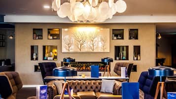 A modern lounge area with a fireplace, leather sofas, and a large abstract painting on the wall.