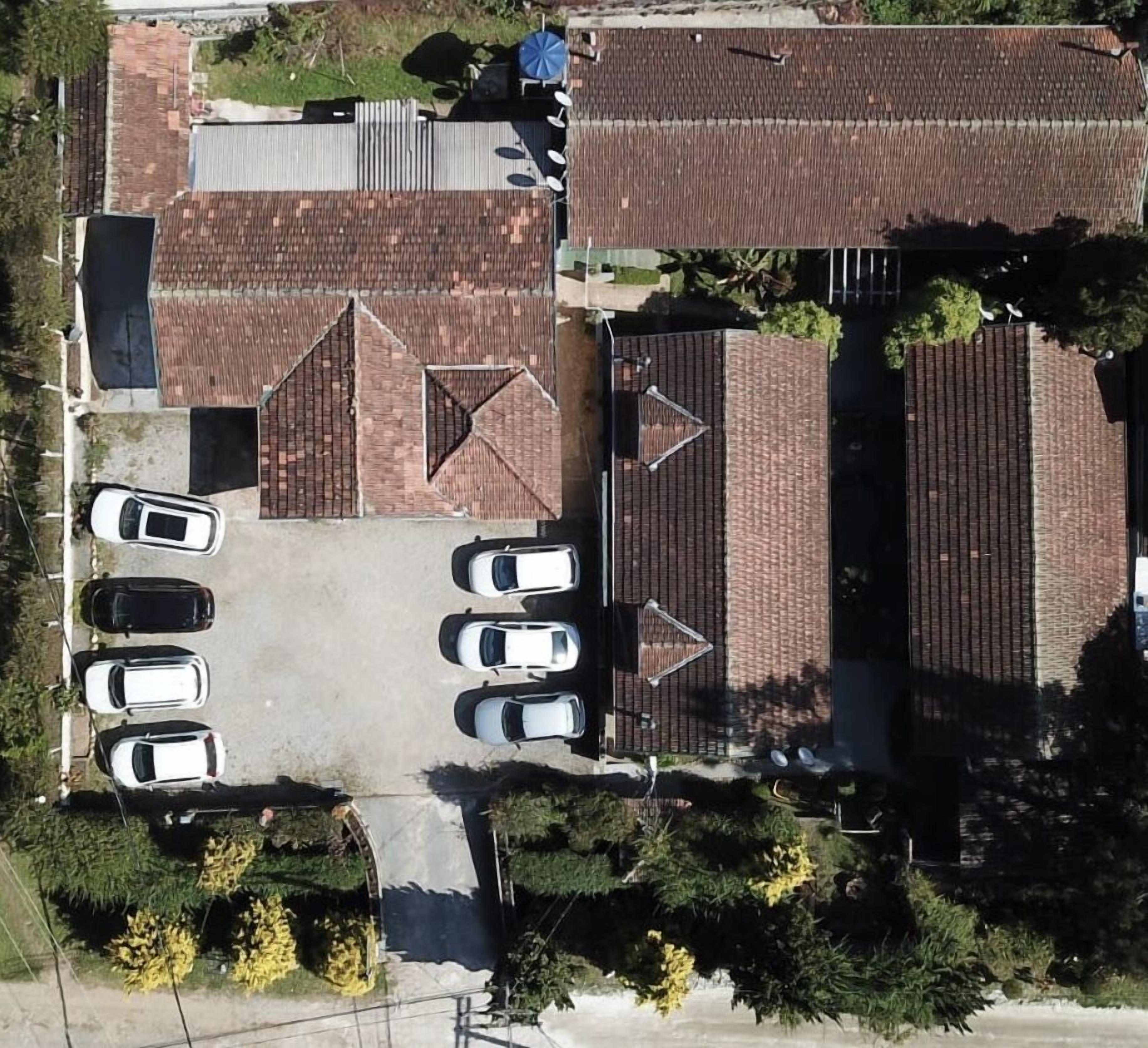 An aerial view of a parking lot with several cars parked in rows.