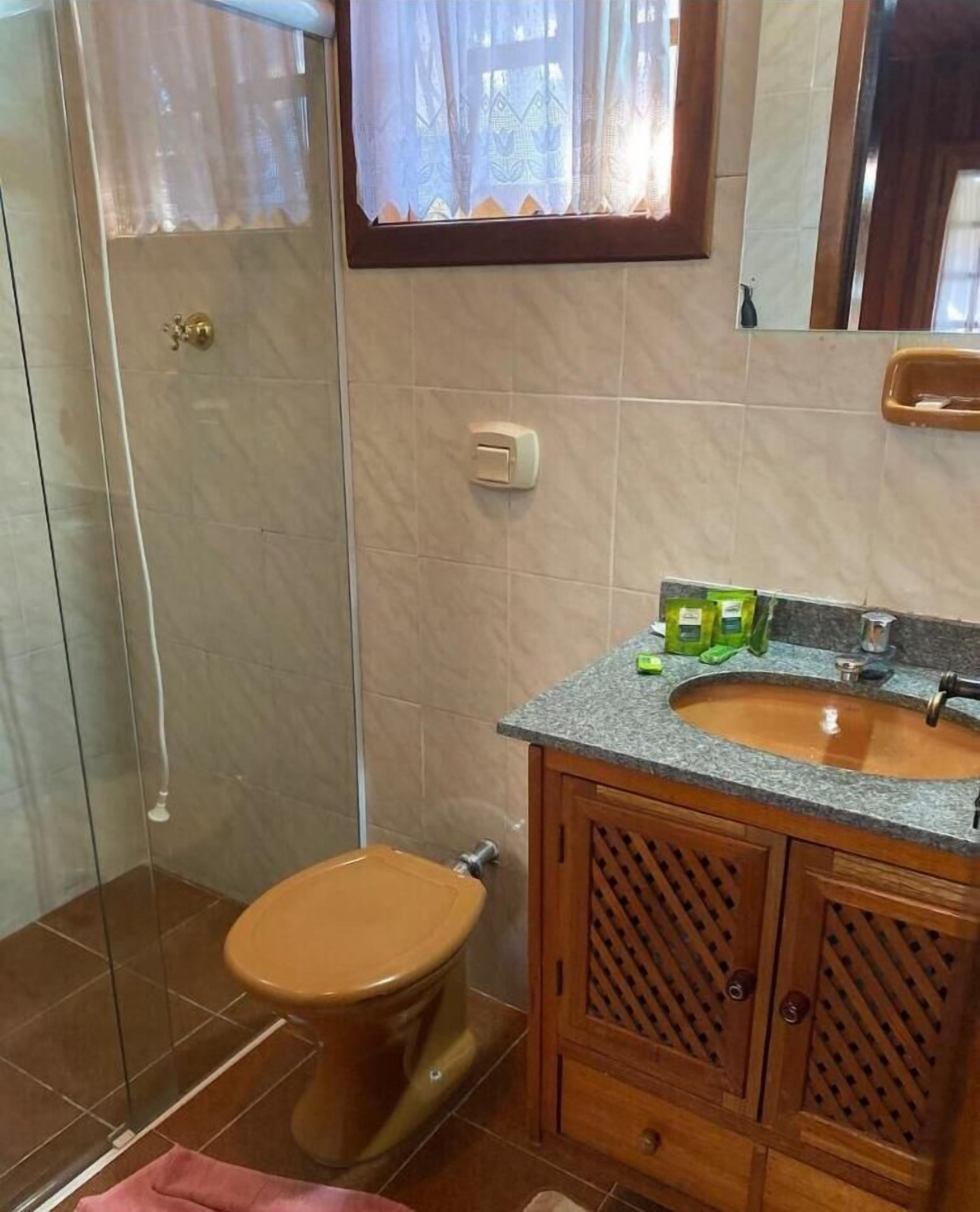 A bathroom with a toilet, a sink, and a shower.