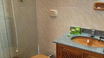 A bathroom with a toilet, a sink, and a shower.