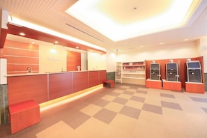 A reception area with a check-in counter, a small seating area, and self-service kiosks. - Richmond Hotel Hamamatsu (Hamamatsu)